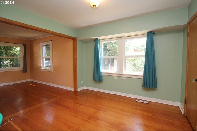 spare room with hardwood / wood-style flooring and a healthy amount of sunlight