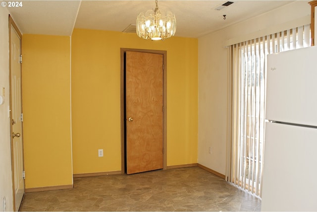 unfurnished room with a textured ceiling and an inviting chandelier