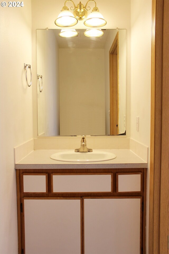 bathroom with a notable chandelier and vanity