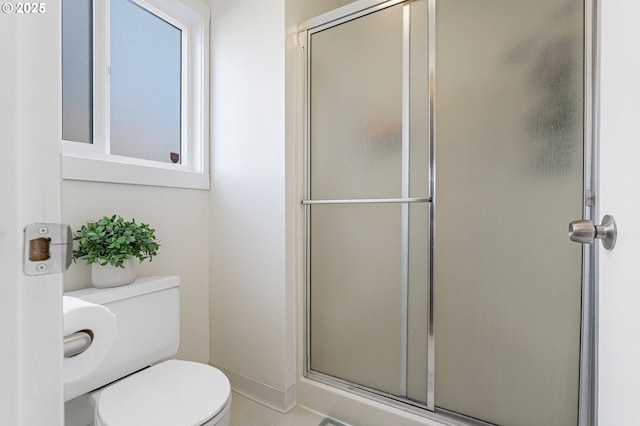 bathroom with toilet, a shower with door, and baseboards