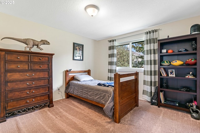 bedroom featuring light carpet, a textured ceiling, and baseboards