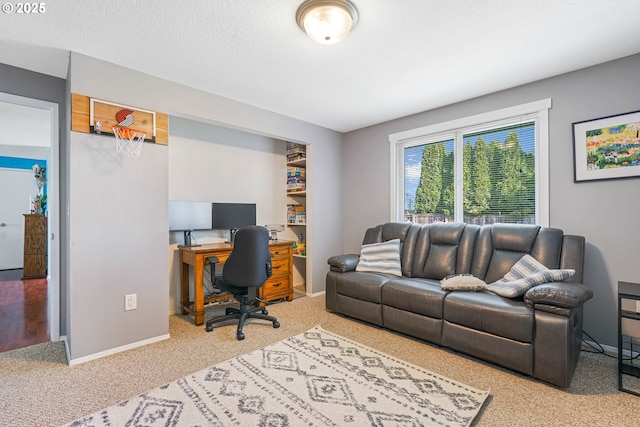 carpeted home office with baseboards and a textured ceiling