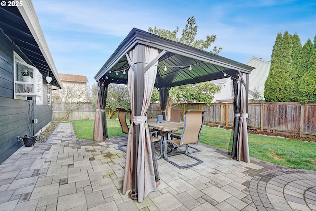 view of patio / terrace featuring a gazebo, outdoor dining area, and a fenced backyard