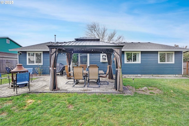 rear view of property with fence, a patio, a gazebo, and a lawn