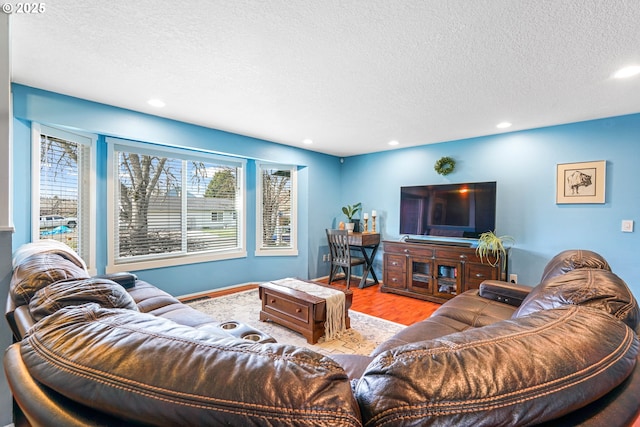 living room with recessed lighting, a healthy amount of sunlight, a textured ceiling, and wood finished floors