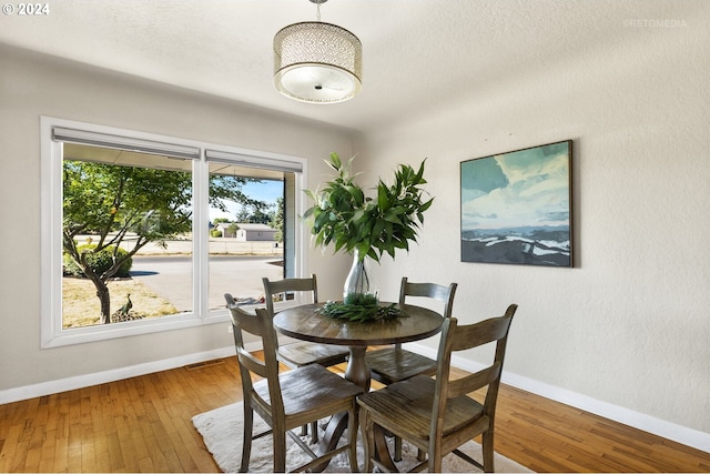 dining room featuring hardwood / wood-style floors and a textured ceiling