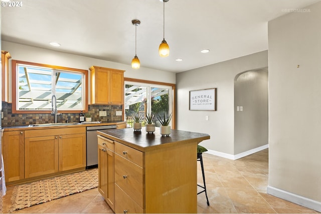 kitchen featuring decorative backsplash, sink, pendant lighting, dishwasher, and a kitchen island