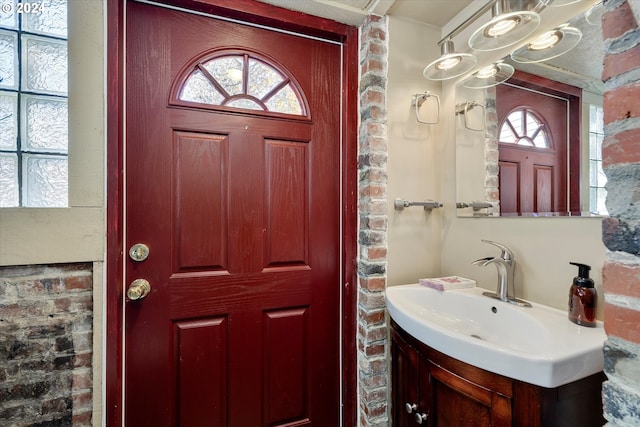 interior space with vanity and brick wall