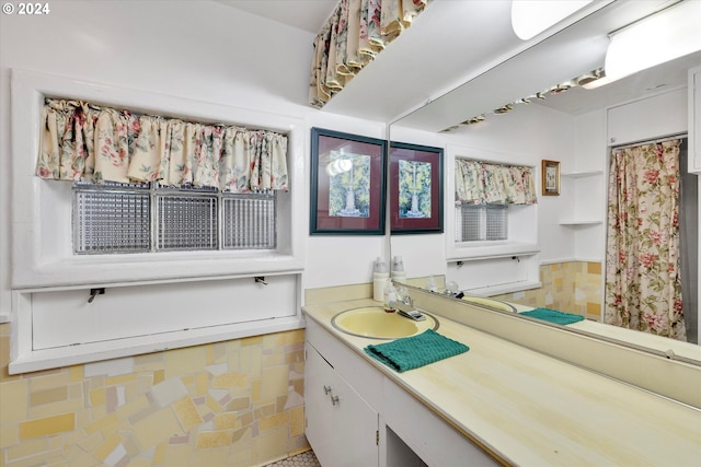 bathroom with vanity and tile walls