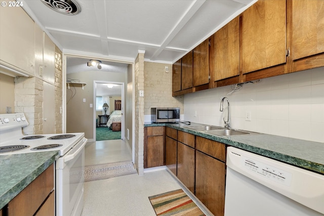 kitchen featuring backsplash, sink, and white appliances