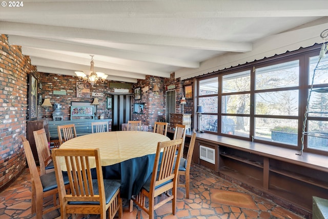 dining space featuring beamed ceiling, brick wall, and an inviting chandelier