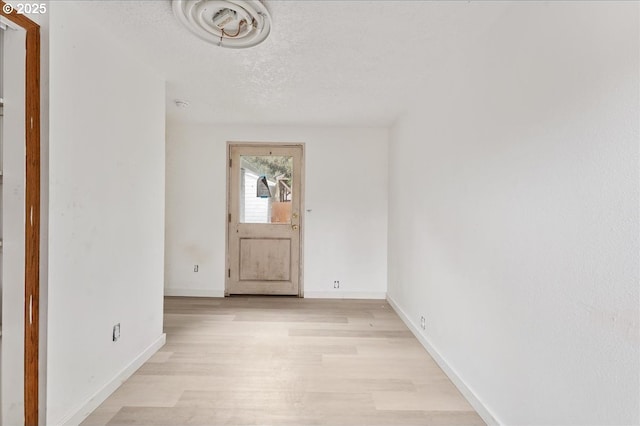 entryway with a textured ceiling and light hardwood / wood-style floors