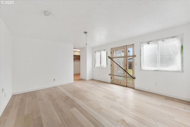 spare room featuring a textured ceiling and light wood-type flooring