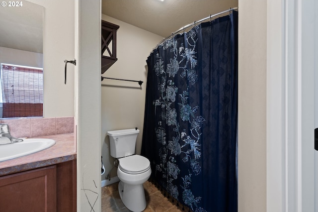 bathroom with toilet, vanity, and tile patterned flooring