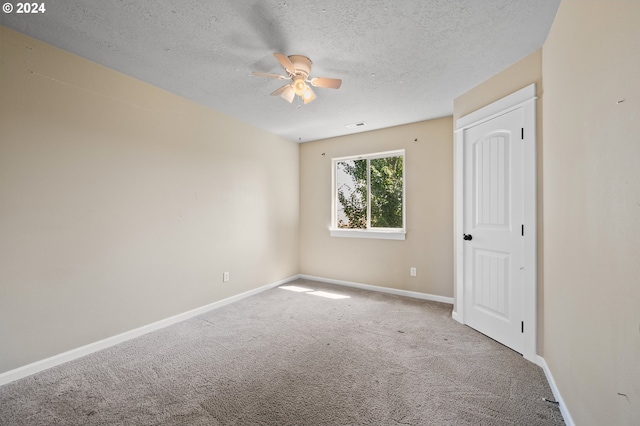 carpeted spare room with ceiling fan and a textured ceiling