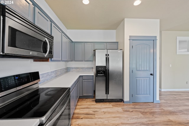 kitchen with light hardwood / wood-style flooring, appliances with stainless steel finishes, and gray cabinets