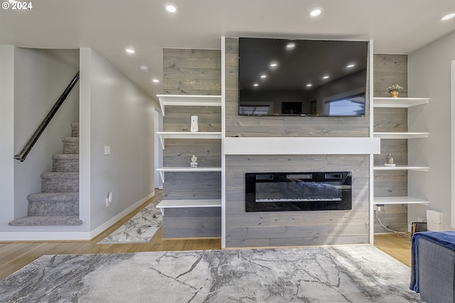 living room with a tile fireplace and wood-type flooring