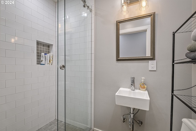 bathroom featuring a shower with door and sink