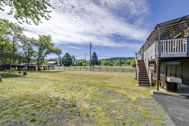 view of yard featuring a wooden deck and a rural view