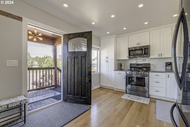 kitchen featuring stainless steel appliances, white cabinetry, tasteful backsplash, and light hardwood / wood-style floors