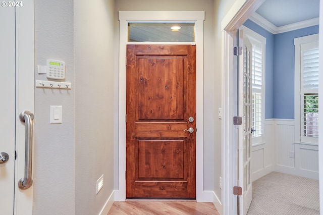 foyer entrance featuring ornamental molding and light hardwood / wood-style flooring