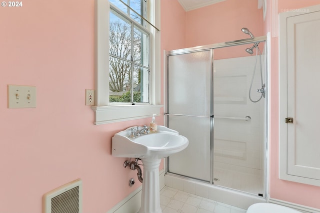 bathroom featuring toilet, tile flooring, and an enclosed shower