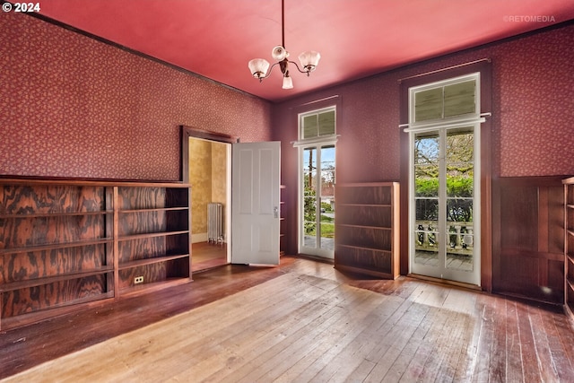 interior space featuring an inviting chandelier, radiator heating unit, and hardwood / wood-style floors