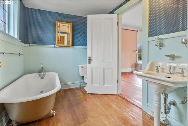 bathroom with hardwood / wood-style flooring and a bath to relax in