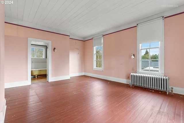 empty room featuring radiator and dark hardwood / wood-style floors