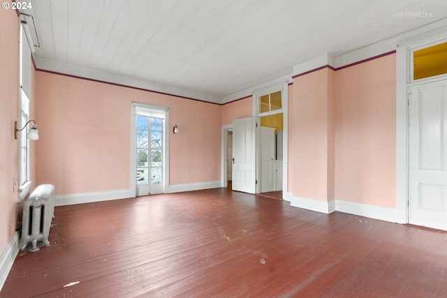 empty room with dark hardwood / wood-style flooring and radiator