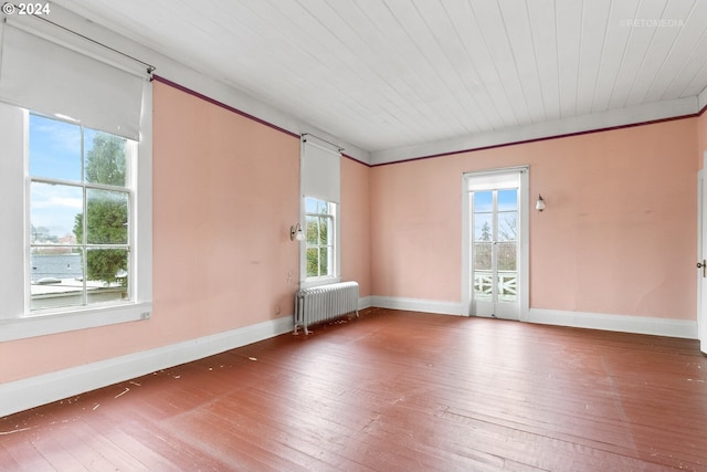 empty room with radiator heating unit, wood ceiling, and dark hardwood / wood-style floors