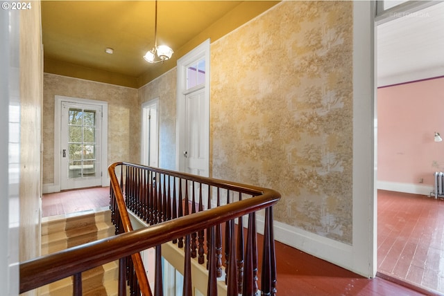 hall with an inviting chandelier and dark wood-type flooring