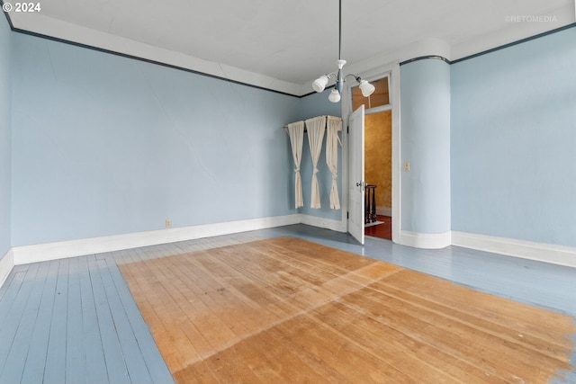 unfurnished room with a notable chandelier and hardwood / wood-style floors