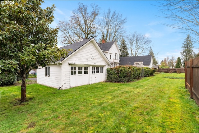 back of property with a lawn and a garage