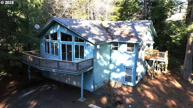 rear view of house featuring a wooden deck