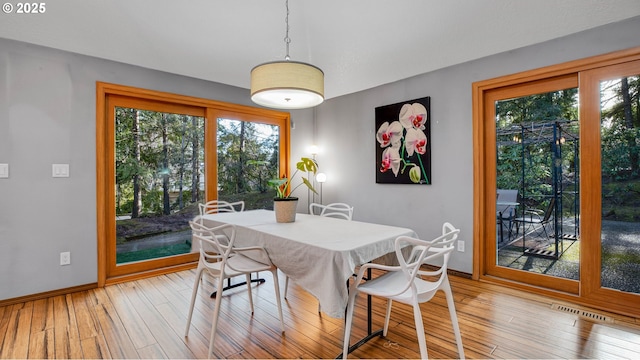 dining space with light hardwood / wood-style floors