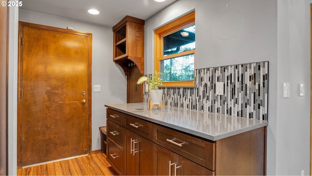 kitchen with light wood-type flooring and decorative backsplash