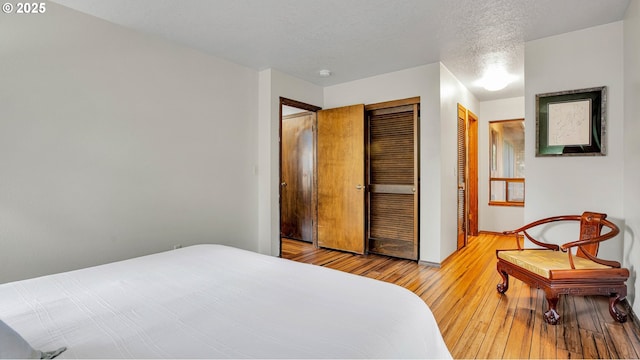 bedroom featuring a textured ceiling and light wood-type flooring