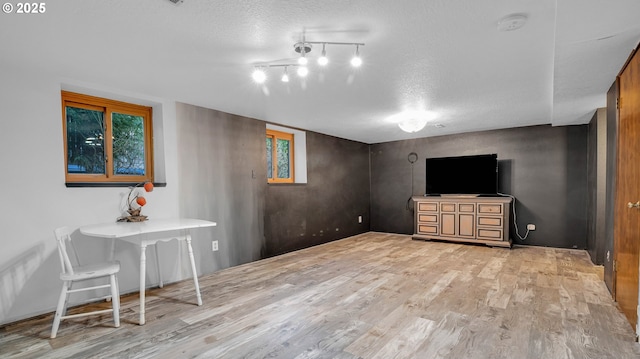 living room with a textured ceiling and light wood-type flooring