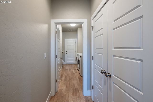 hall with light wood-type flooring and washing machine and clothes dryer