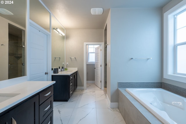 bathroom with vanity and shower with separate bathtub