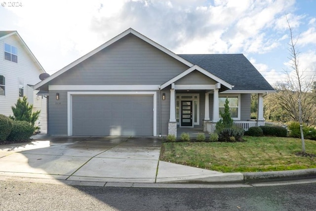 craftsman house featuring a front yard, a porch, and a garage