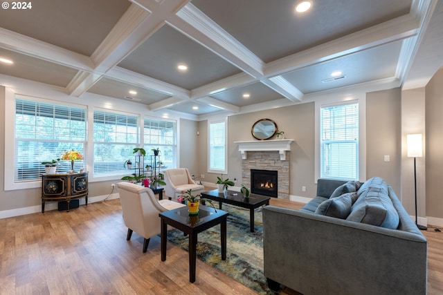 living room with coffered ceiling, beamed ceiling, light hardwood / wood-style floors, a fireplace, and ornamental molding