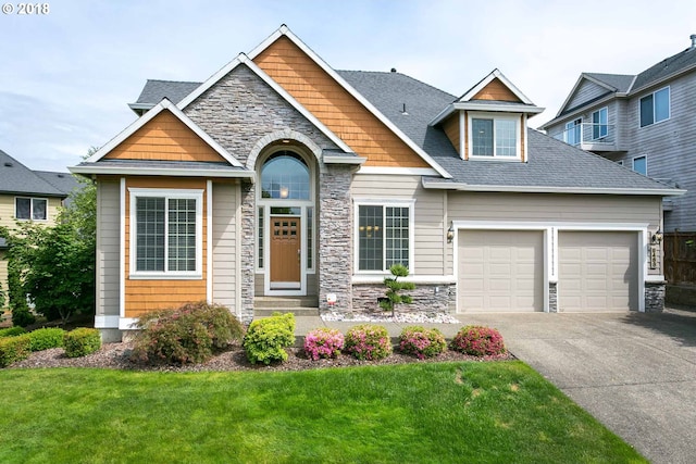 craftsman house featuring stone siding, an attached garage, concrete driveway, and a front lawn