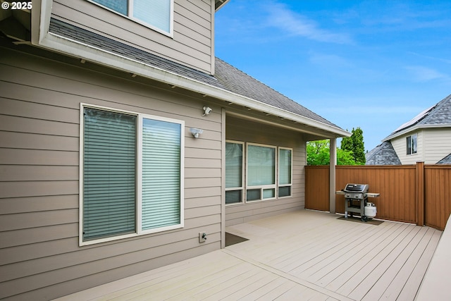 deck featuring grilling area and fence