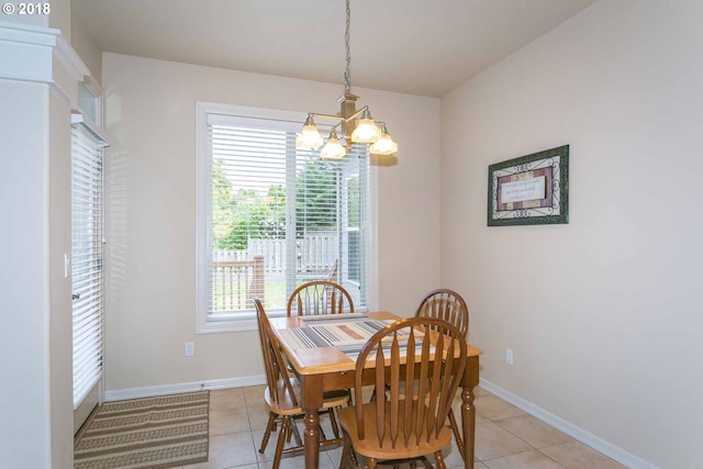 dining room featuring a chandelier, light tile patterned floors, and baseboards