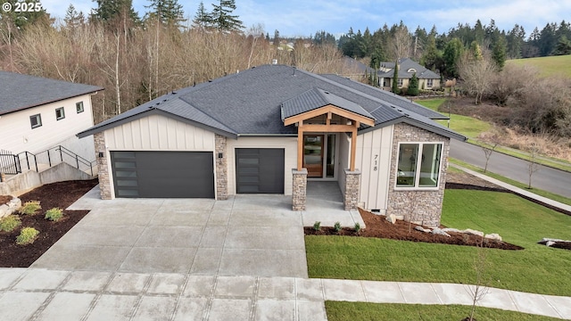 view of front facade with an attached garage, a front lawn, board and batten siding, and concrete driveway