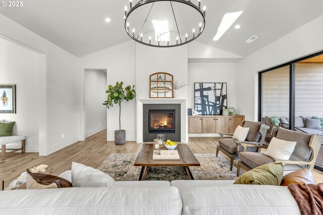 living room with lofted ceiling, sink, and light hardwood / wood-style flooring