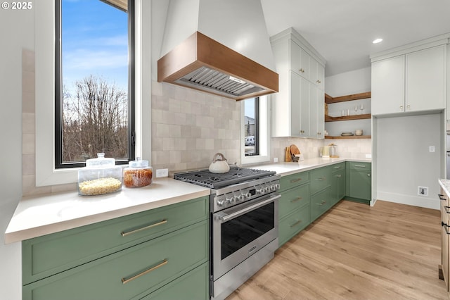 kitchen with light countertops, premium range hood, stainless steel range, and white cabinets