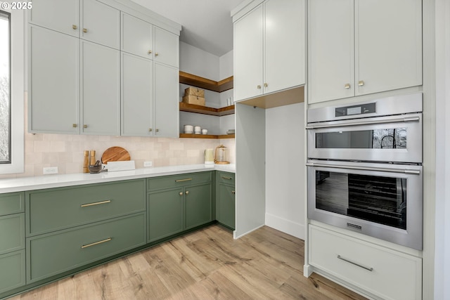 kitchen featuring double oven, white cabinets, light countertops, decorative backsplash, and open shelves